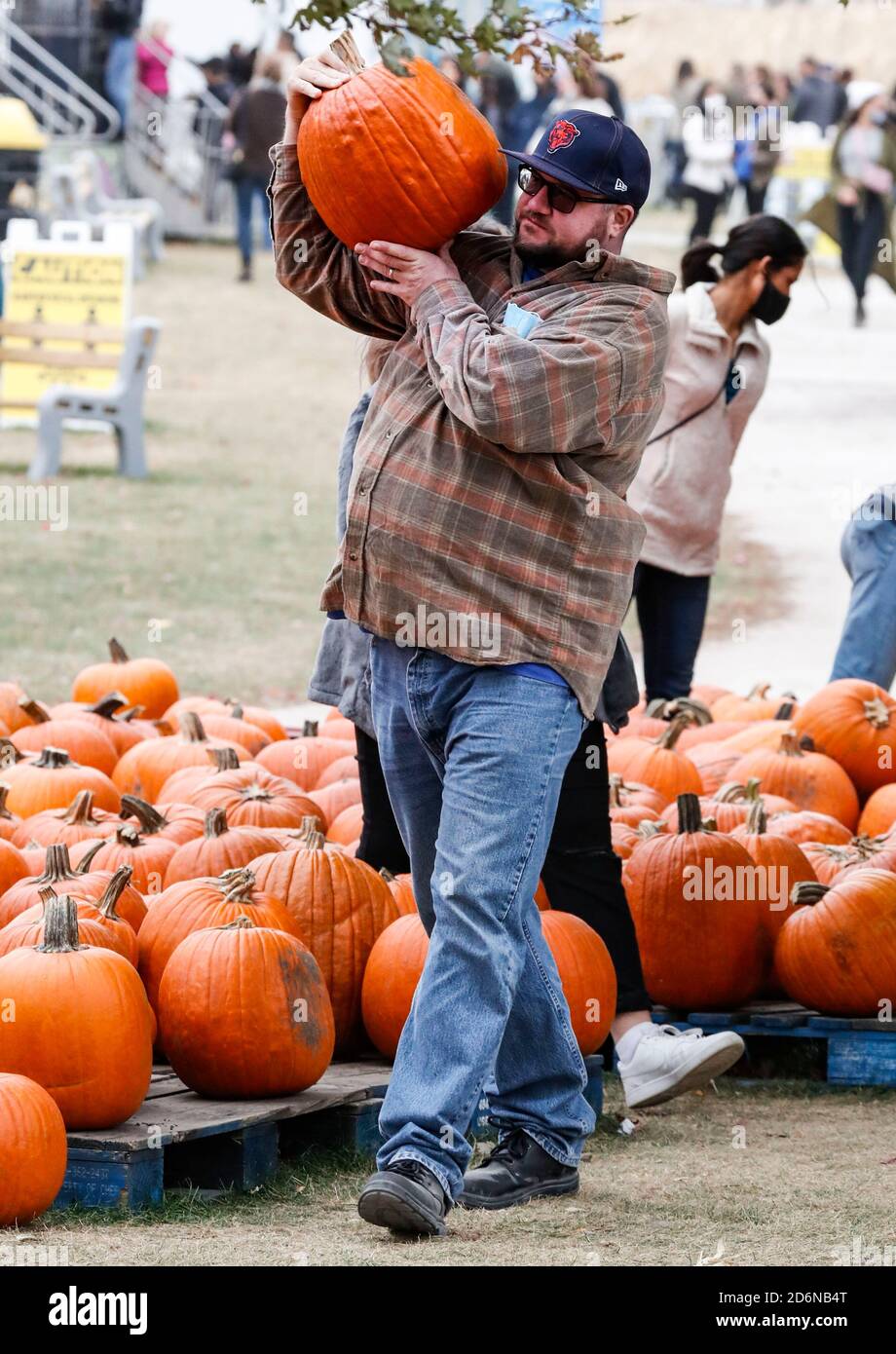 Lincolnshire, Stati Uniti. 18 Ott 2020. Un visitatore trasporta una zucca scelta ad un Pumpkinfest in Lincolnshire, Illinois, Stati Uniti, il 17 ottobre 2020. Molte città dell'Illinois stanno organizzando festival della zucca di recente prima dell'Halloween. Credit: Joel Lerner/Xinhua/Alamy Live News Foto Stock