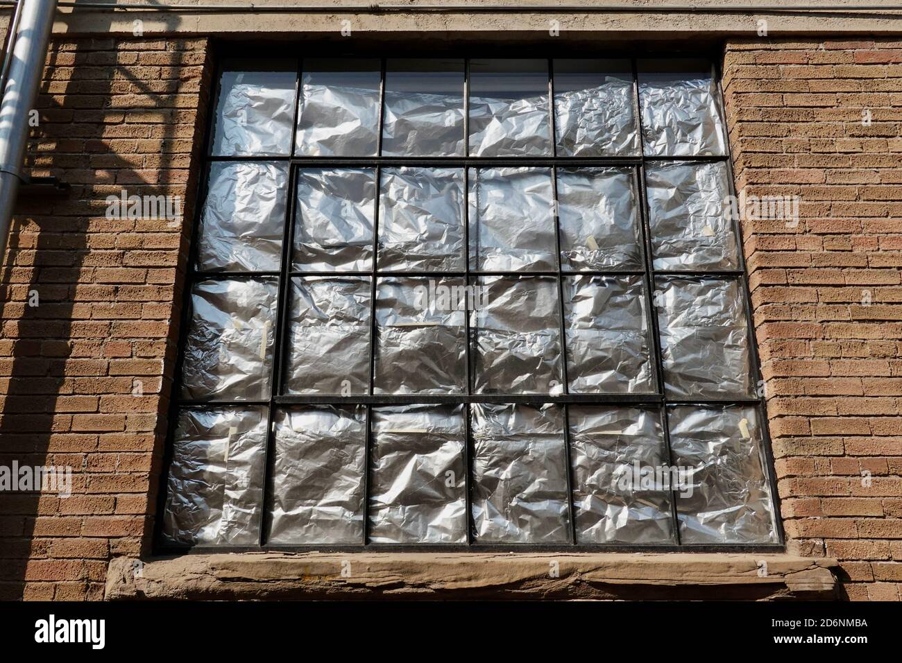 Il tinfoil è fissato su una finestra per impedire alla luce di entrare in una stanza. Foto Stock