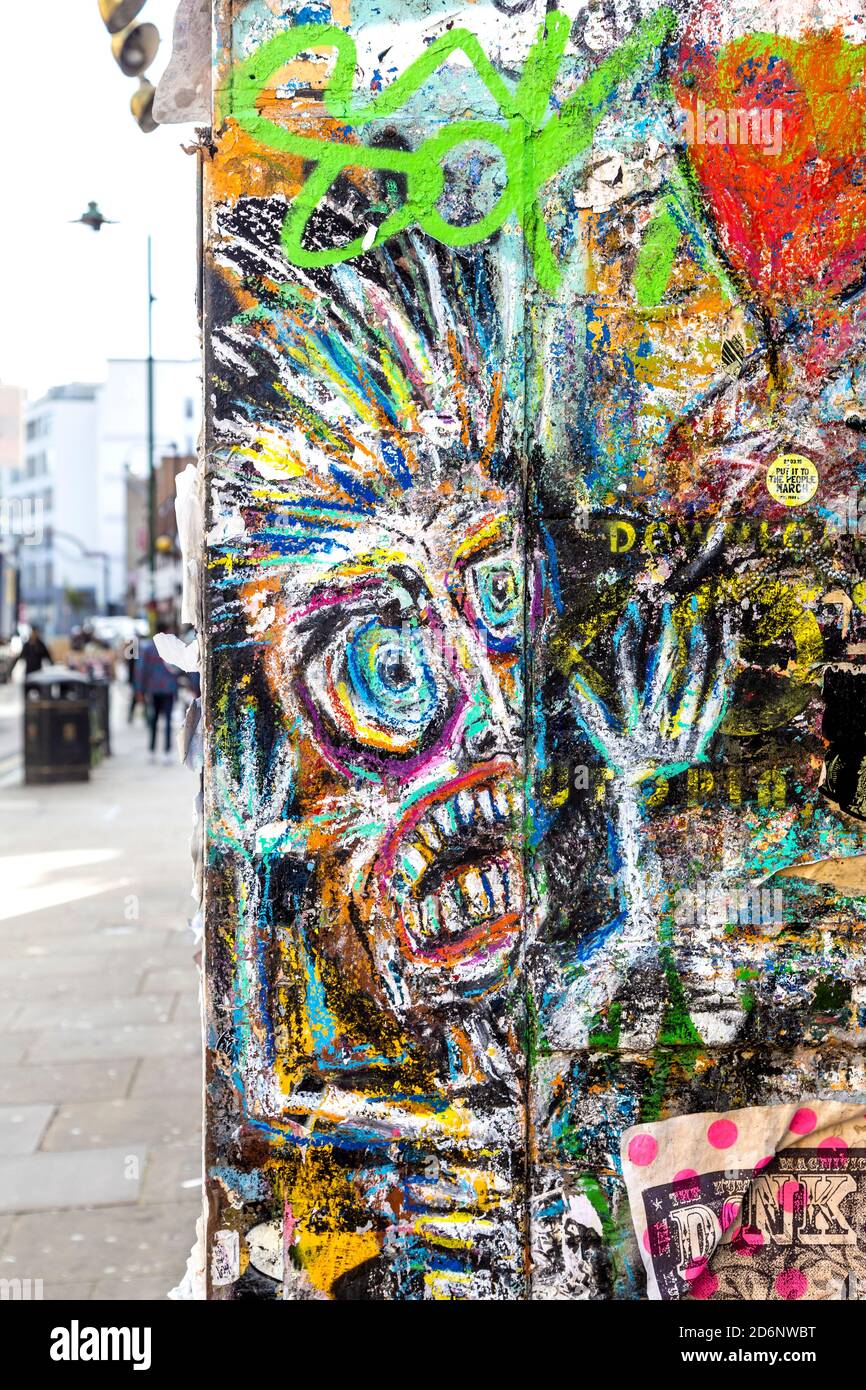 Pareti ricoperte di graffiti, poster e opere d'arte di Brick Lane, East London, UK Foto Stock