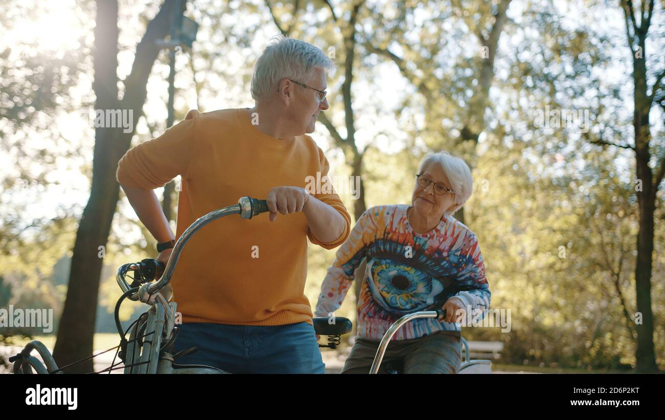 Coppia senior in bicicletta doppia in autunno. Nonna e nonno in bicicletta insieme . Anziani stile di vita sano e attivo. Foto di alta qualità Foto Stock