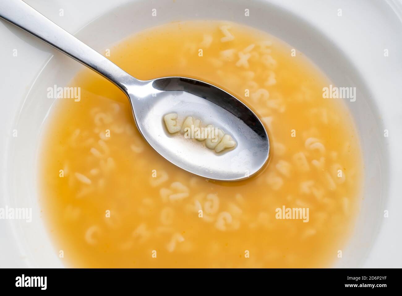 piatto a zuppa di alfabeti con un cucchiaio contenente il messaggio di godere, vista dall'alto Foto Stock
