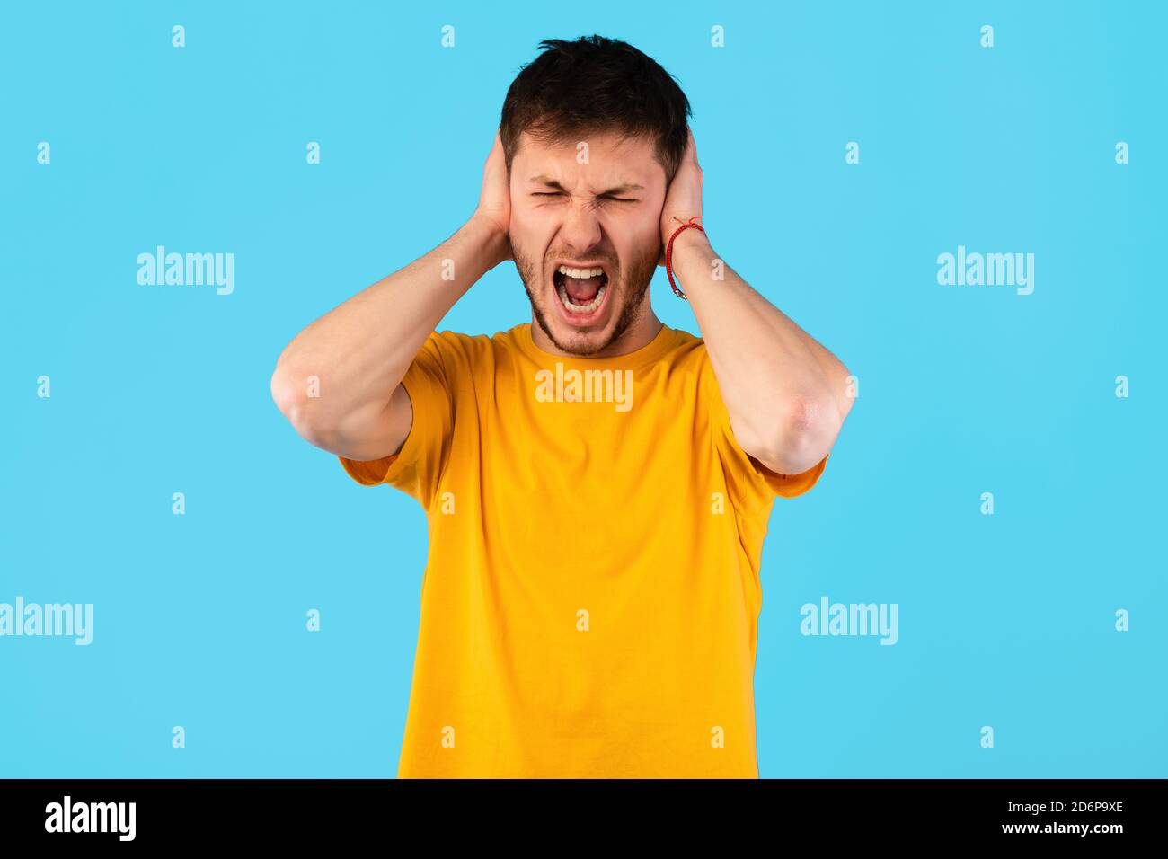 Giovane arrabbiato urlando e afferrando la testa Foto Stock