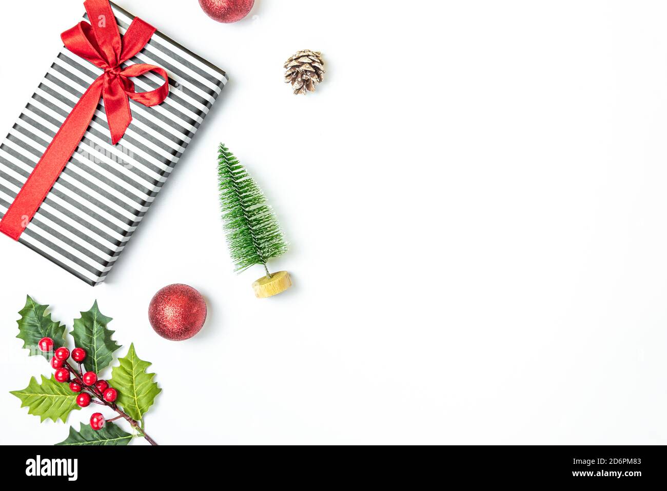Confezione regalo confezionata in bianco e nero a righe su sfondo bianco. Regali di Natale e preparazione ornamentale. Spazio di copia. Foto Stock