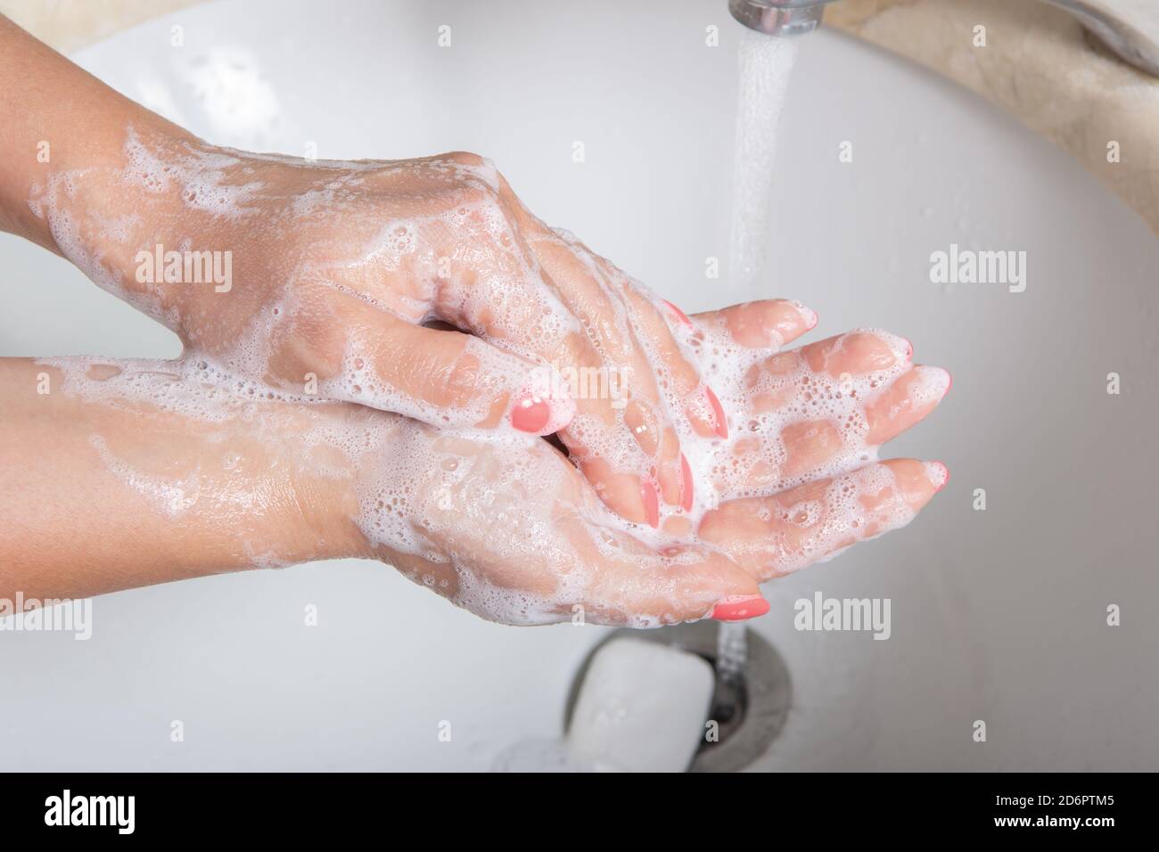 La donna usa sapone e le mani di lavaggio sotto l'acqua corrente. Concetto di igiene dettaglio delle mani. Lavarsi la mano - concetto di igiene e assistenza sanitaria Foto Stock