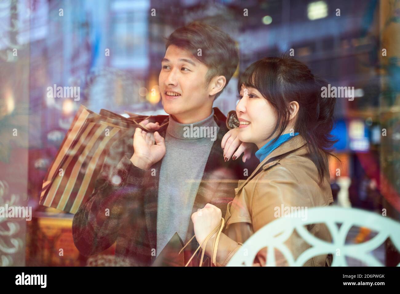 felice giovane coppia asiatica che guarda alla vetrina in stile moderno città Foto Stock