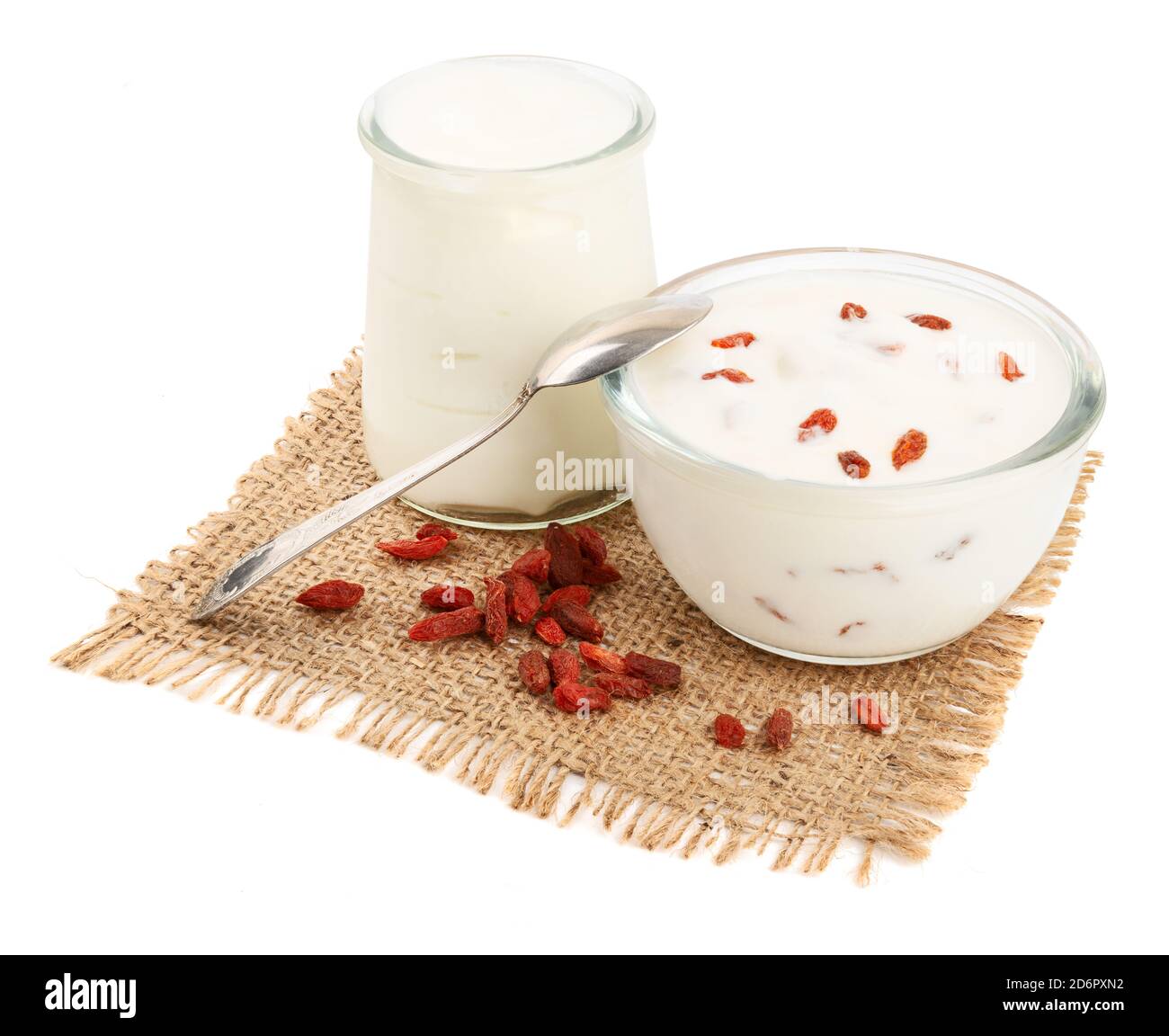 Yogurt bianchi sani in ciotole di vetro con frutti di bosco goji un tovagliolo di sackcloth Foto Stock