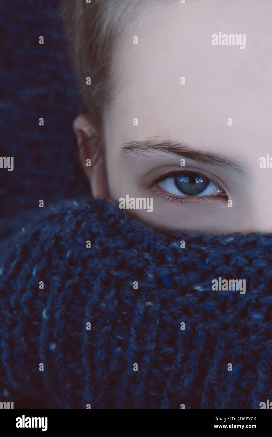 Bella ragazza con gli occhi blu si avvolse in un caldo pullover in maglia blu Foto Stock