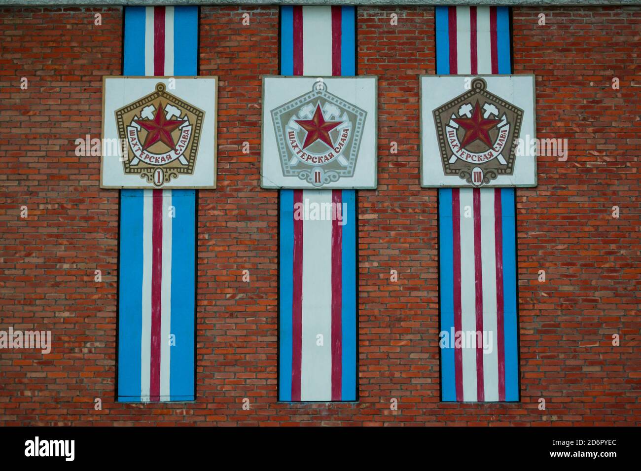Bandiere russe su un edificio nella città artica Pyramiden a Svalbard, Norvegia. Pyramiden è un insediamento abbandonato di miniere di carbone a Svalbard. La piccola città artica fu abbandonata nel 1998. Foto Stock