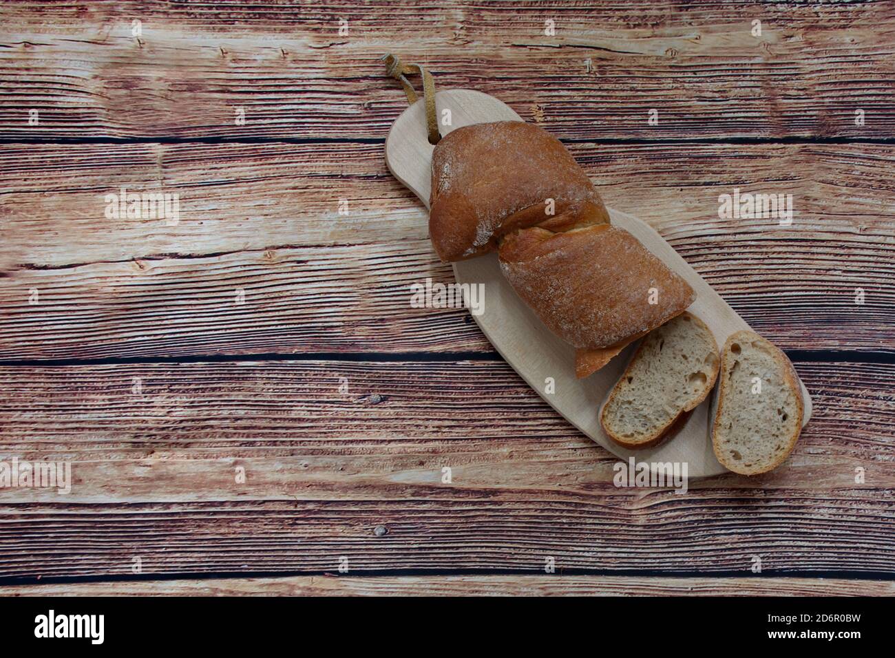 Vista dall'alto del pane appena sfornato sul tagliere sfondo di legno Foto Stock