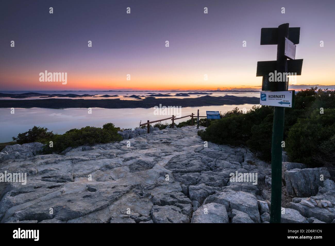 Puntatori percorso sulla collina Kamenjak. Panorama del lago di Vrana al tramonto, una vista sulla costa e le isole Kornati in lontananza Foto Stock