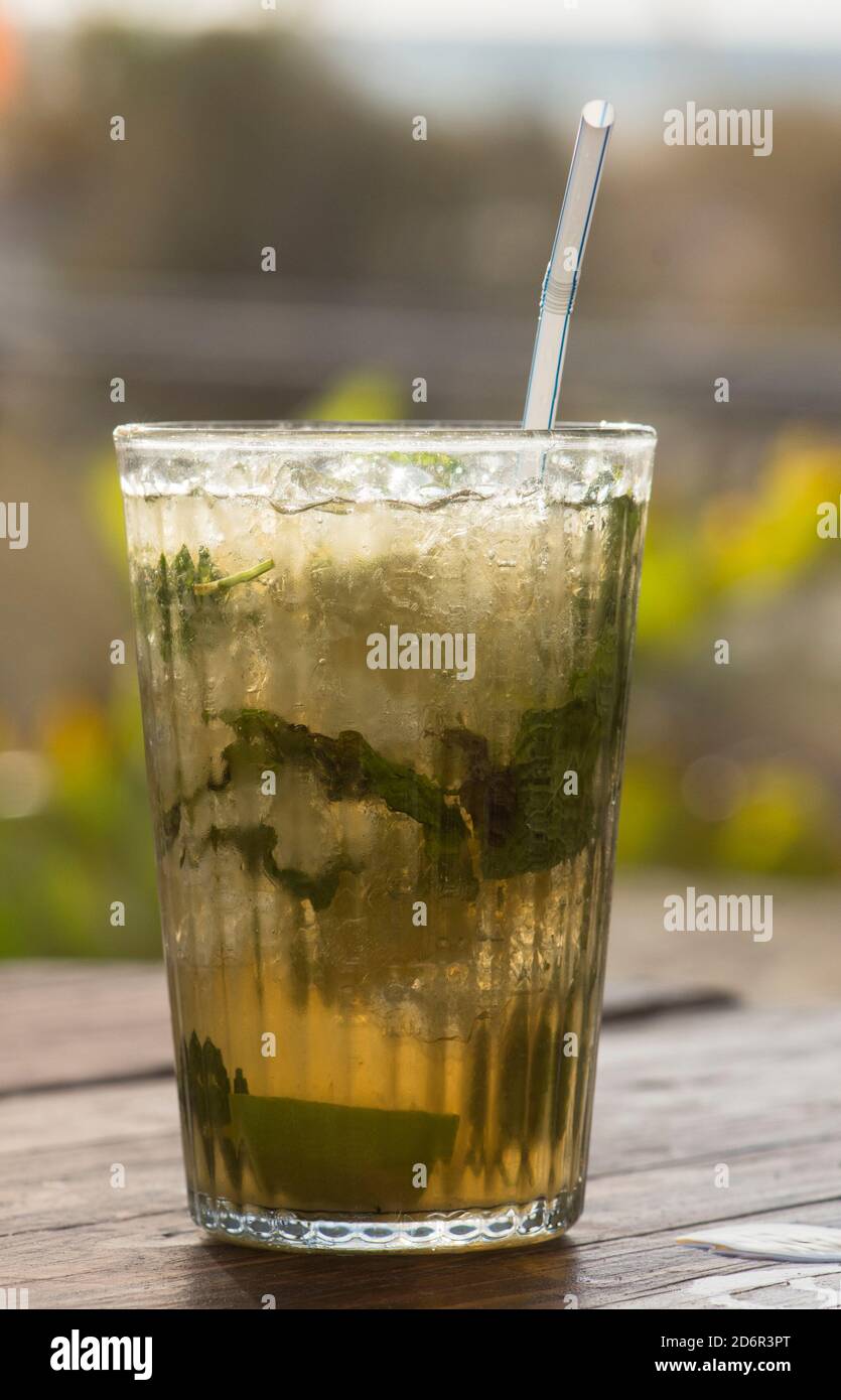 Bicchiere di Mojito, bevanda cubana al rum e un tavolo con paglia. Foto Stock