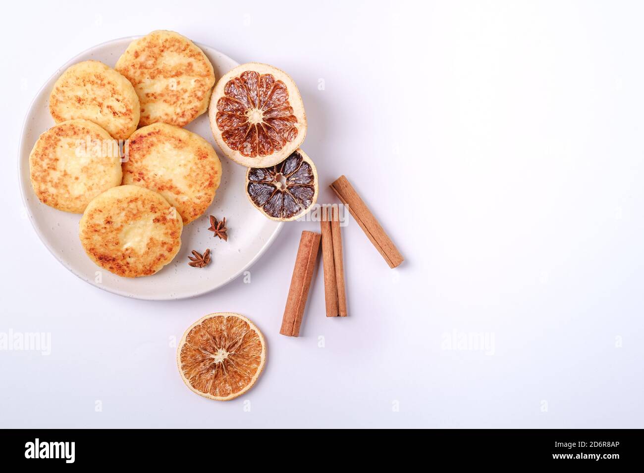 Frittelle di formaggio di cottage. Umore per la colazione di Natale con anice e cannella su sfondo bianco, spazio copia vista dall'alto Foto Stock
