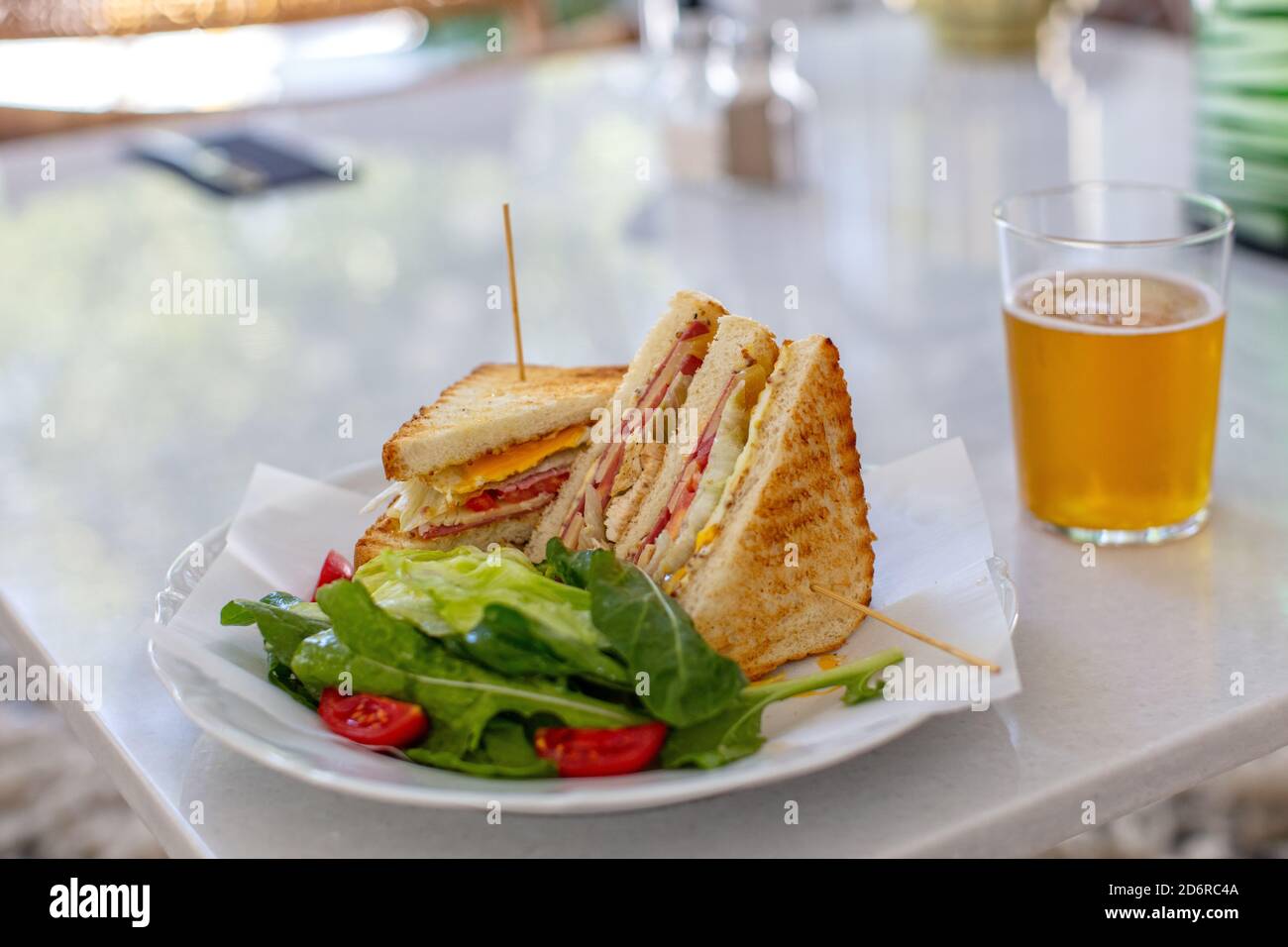 Club Sandwich con un bicchiere di birra su un tavolo. Fast food Foto Stock