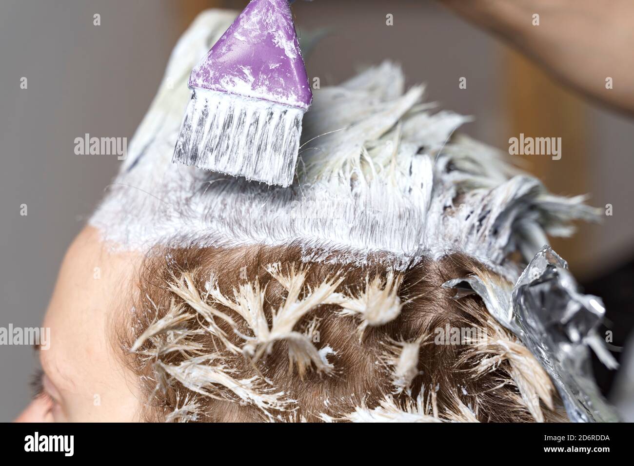 bella donna parrucchiere nel processo di tintura dei capelli a. il cliente che usa foil Foto Stock