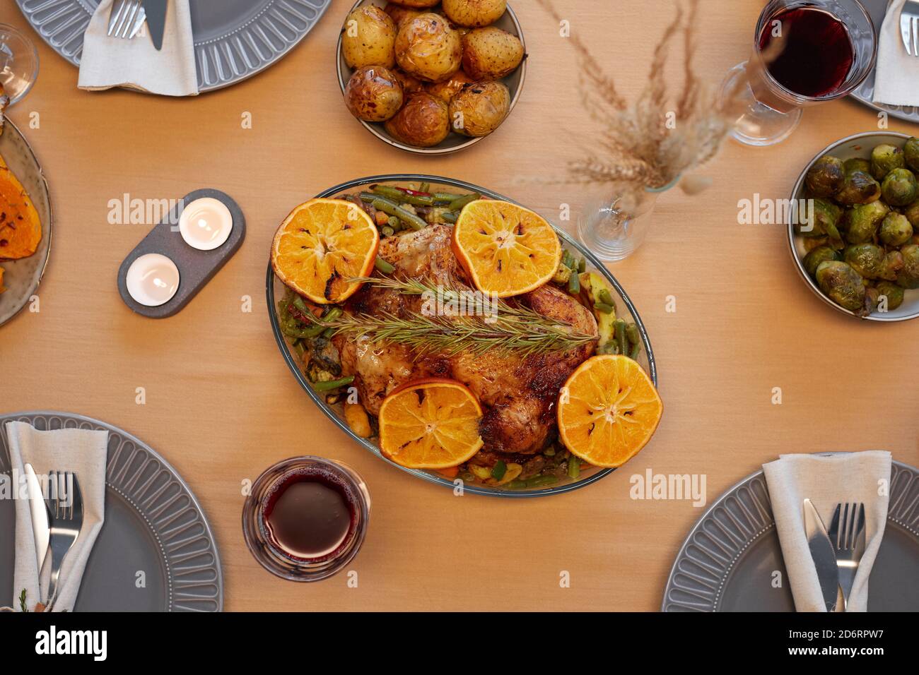 Vista dall'alto sullo sfondo di un delizioso pollo arrosto al tavolo del Ringraziamento pronto per la cena con amici e familiari Foto Stock