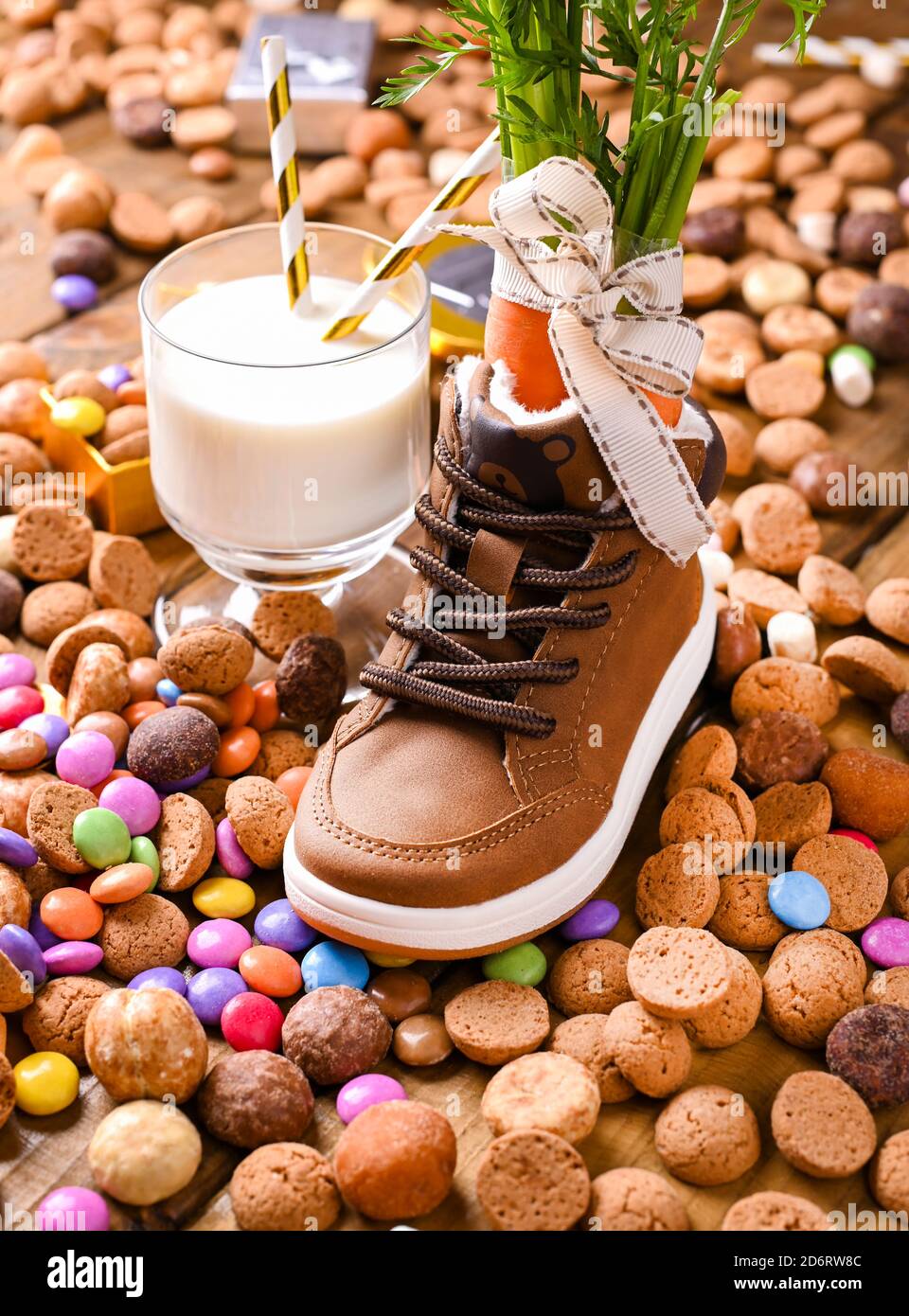 Sinterklaas vacanza olandese . Sfondo in legno con scarpa per bambini con carote per il cavallo di Babbo Natale, un bicchiere di latte, pepernoten e dolci . Foto di alta qualità Foto Stock