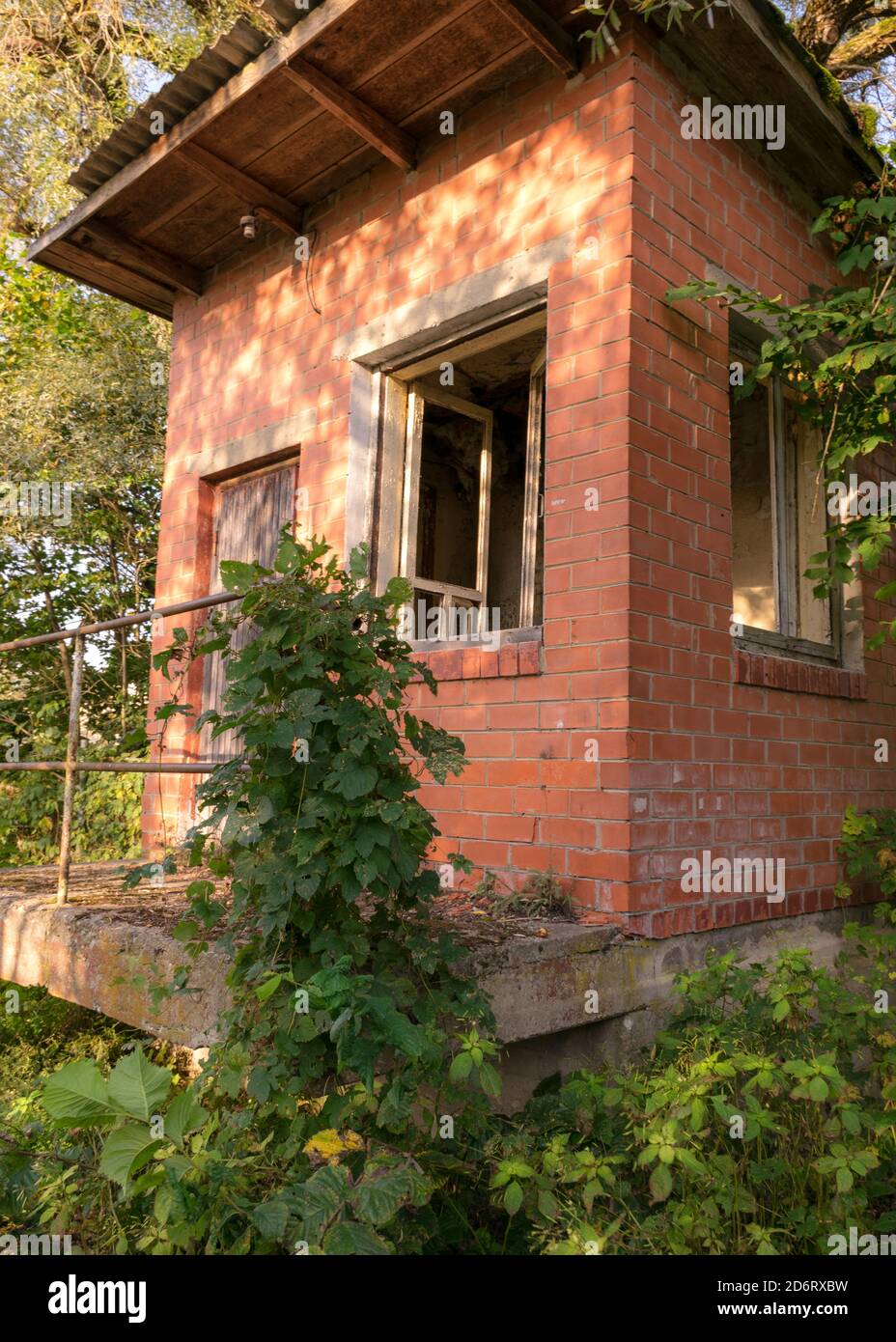 immagine con una vecchia casa di mattoni rossi, finestre senza vetro Foto Stock