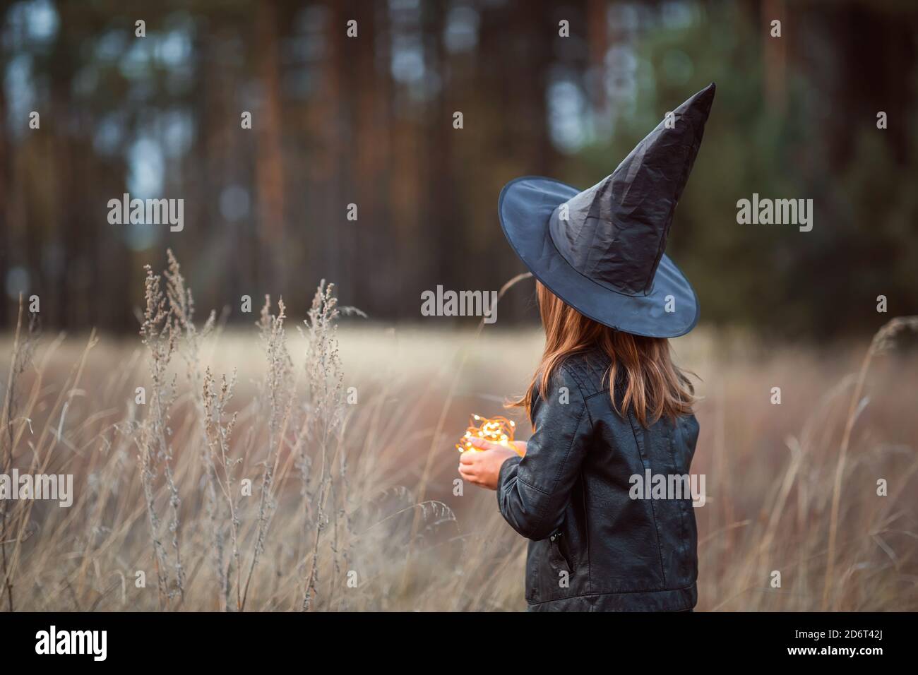 Ragazza carina in un costume di Halloween che tiene una torcia. Foto Stock