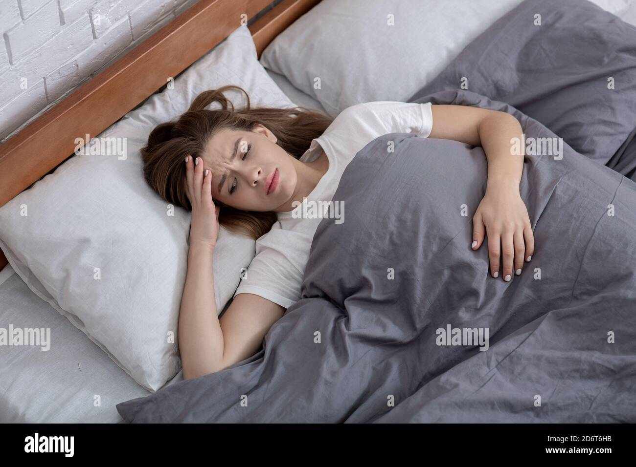 Disturbi della salute mentale. Vista dall'alto di una donna infelice sdraiata a letto, affetta da depressione, ansia o insonnia Foto Stock