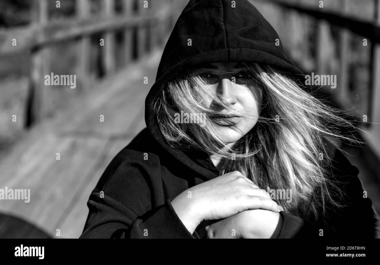 Ritratto di una ragazza adolescente in una felpa con cappuccio nera all'esterno. Foto Stock