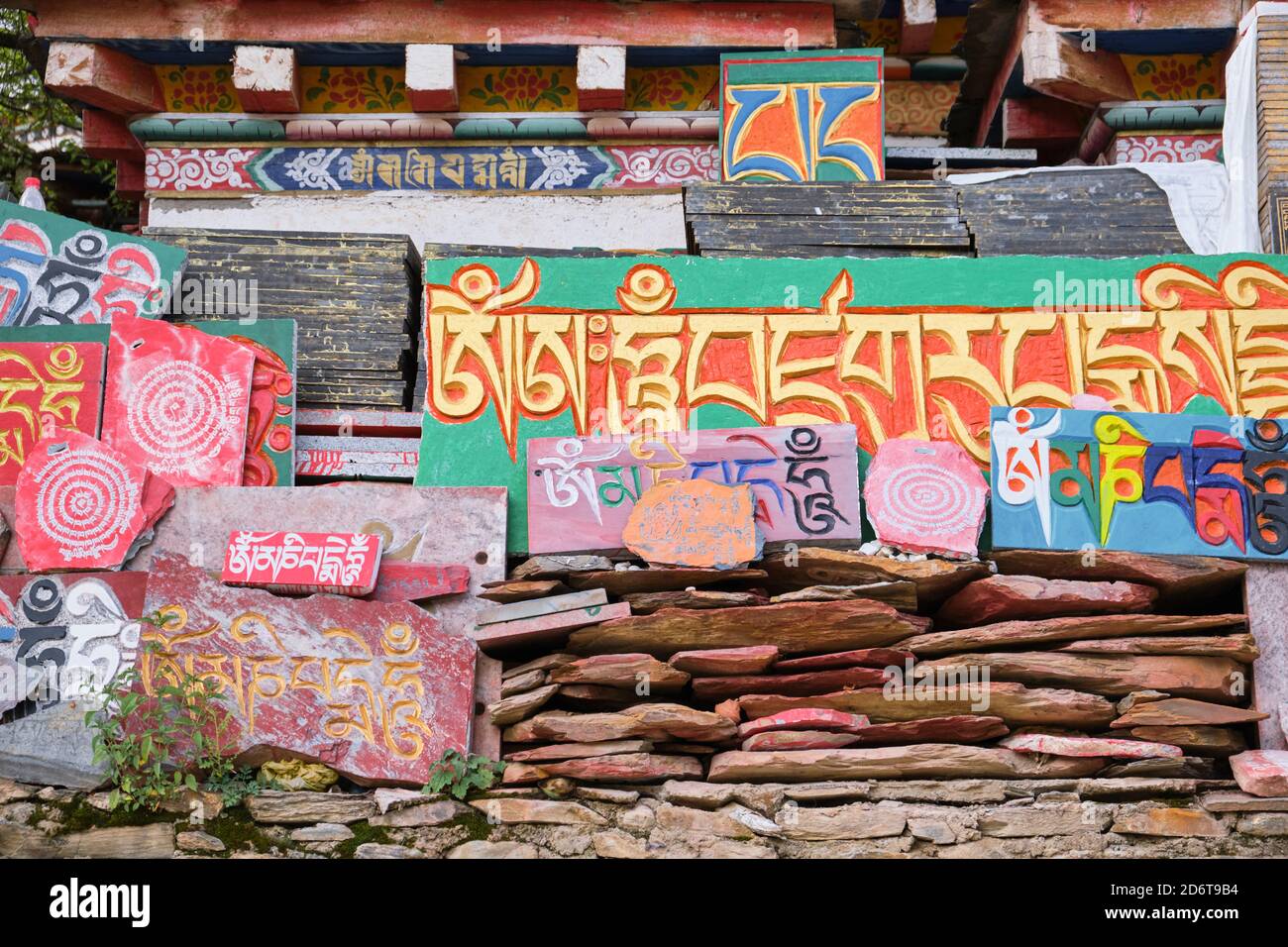Sanscrito mantra Om mani Padme Hum su vibranti lastre di pietra scabra multicolore di giorno Foto Stock