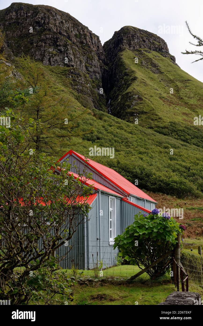 Grazioso cottage con tetto rosso accoccolato sotto le pendici del Beinn An Lochain con una vista magnifica del Alltan na Sroine Gulley. Foto Stock