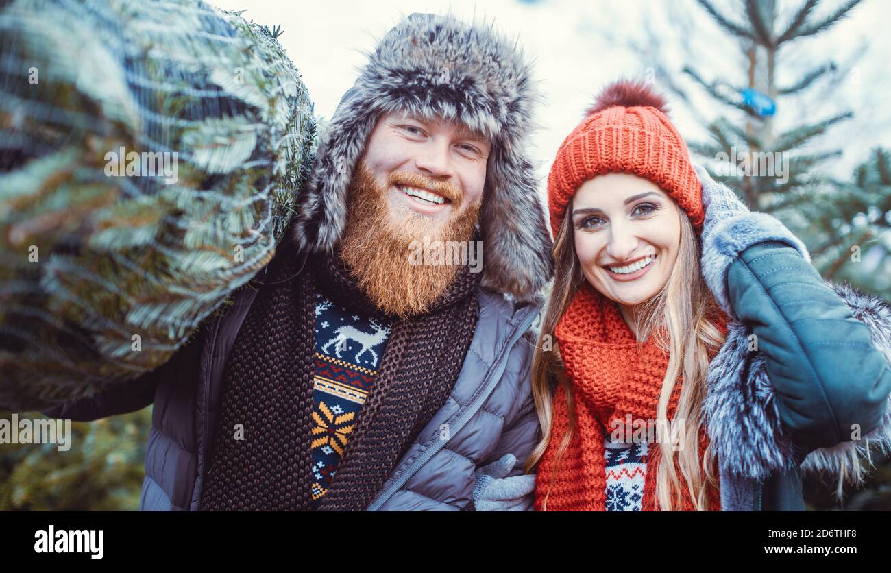 Uomo e donna che hanno comprato un albero di Natale Foto Stock