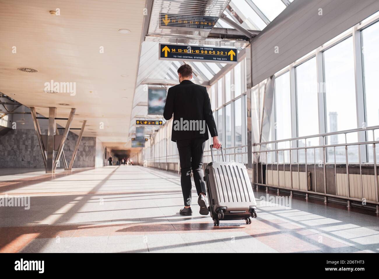 Uomo che trasporta i suoi bagagli attraverso l'aeroporto Foto Stock