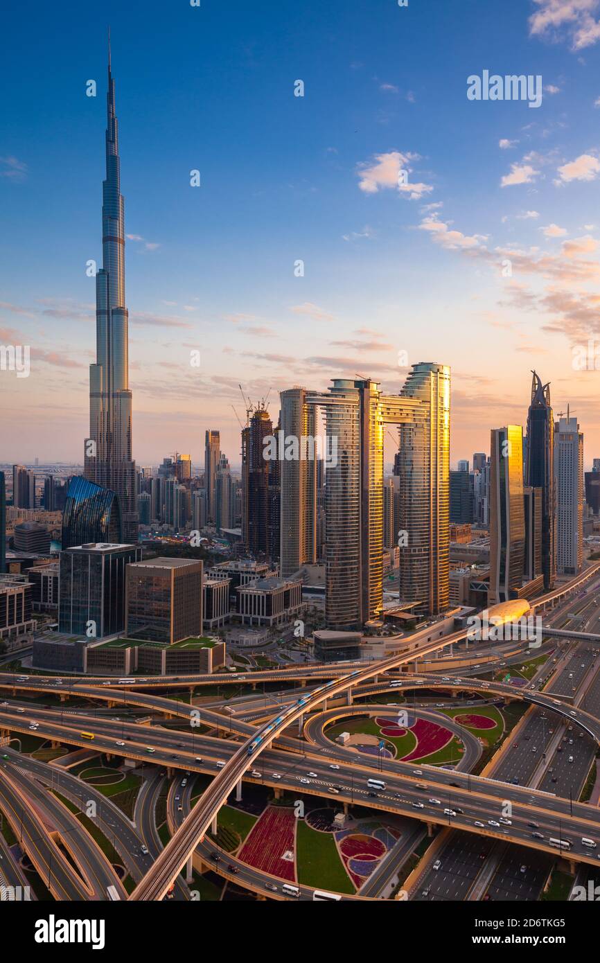 La vista futuristica dello skyline di Dubai al tramonto con Sheikh Zayed Road e Dubai Metro in primo piano Foto Stock