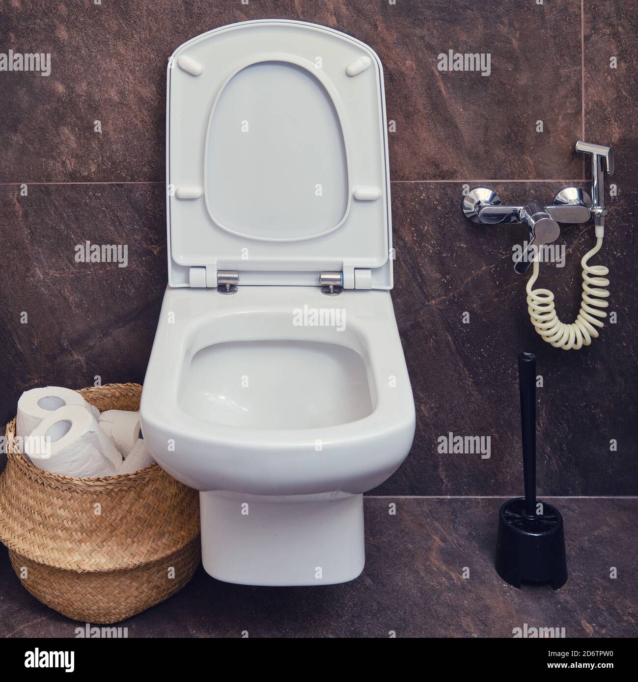 WC con doccia igienica accanto alla spazzola per la pulizia. Cestino di  carta igienica e piastrelle di marmo marrone Foto stock - Alamy