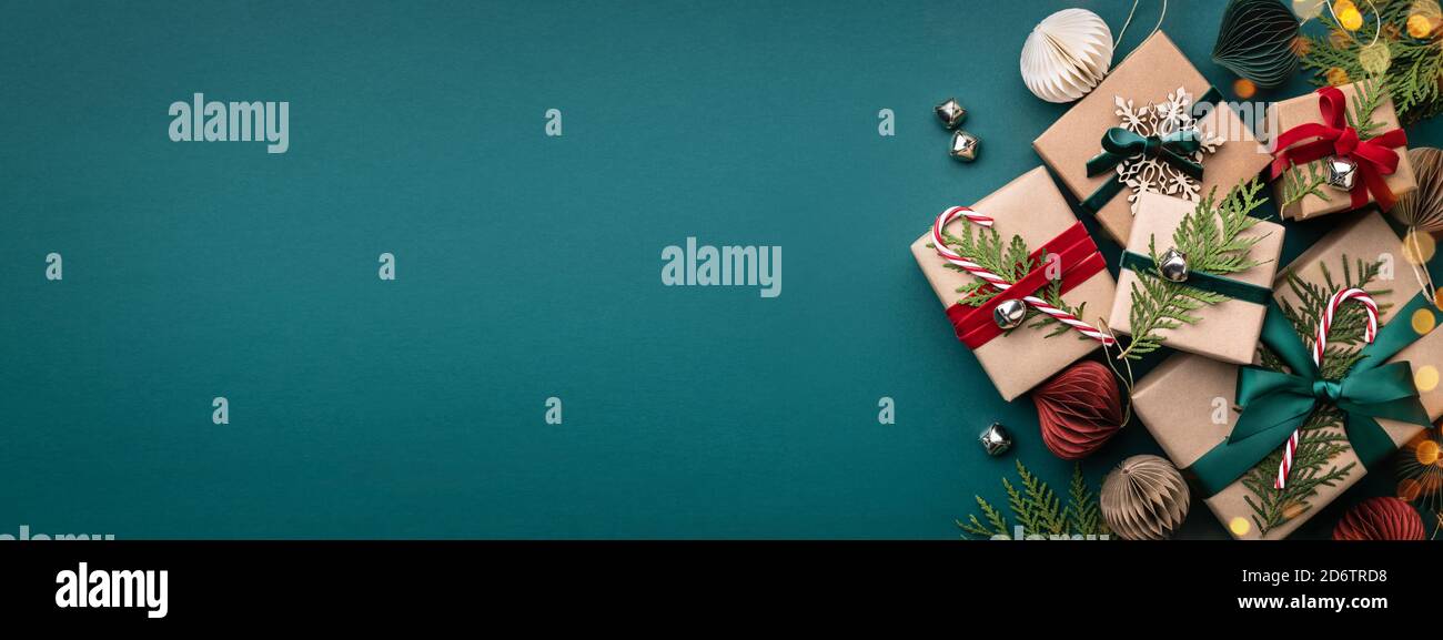 Striscione con molte scatole regalo nastri di velluto legati e decorazioni di carta su sfondo turchese. Sfondo di Natale. Foto Stock