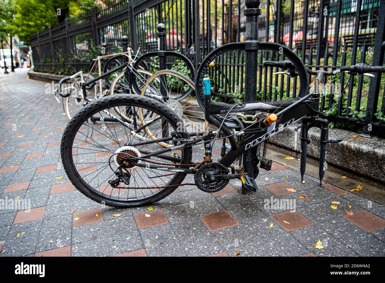 Biciclette abbandonate concatenate ad un posto nella sezione Soho di New York City. Foto Stock