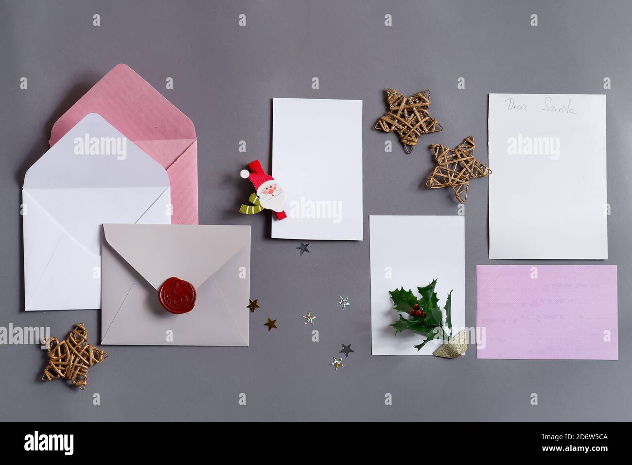 Sfondo festoso da carte di carta mock-up colorate con buste e decorazione di Natale su uno sfondo grigio, spazio di copia. Cartolina di benvenuto. Foto Stock