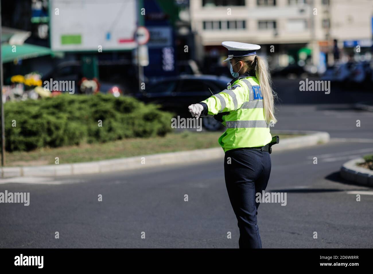 Bucarest, Romania - 18 ottobre 2020: L'ufficiale di polizia femminile tira sopra le automobili nel traffico per controllare se i conducenti rispettano le misure anticovidio. Foto Stock