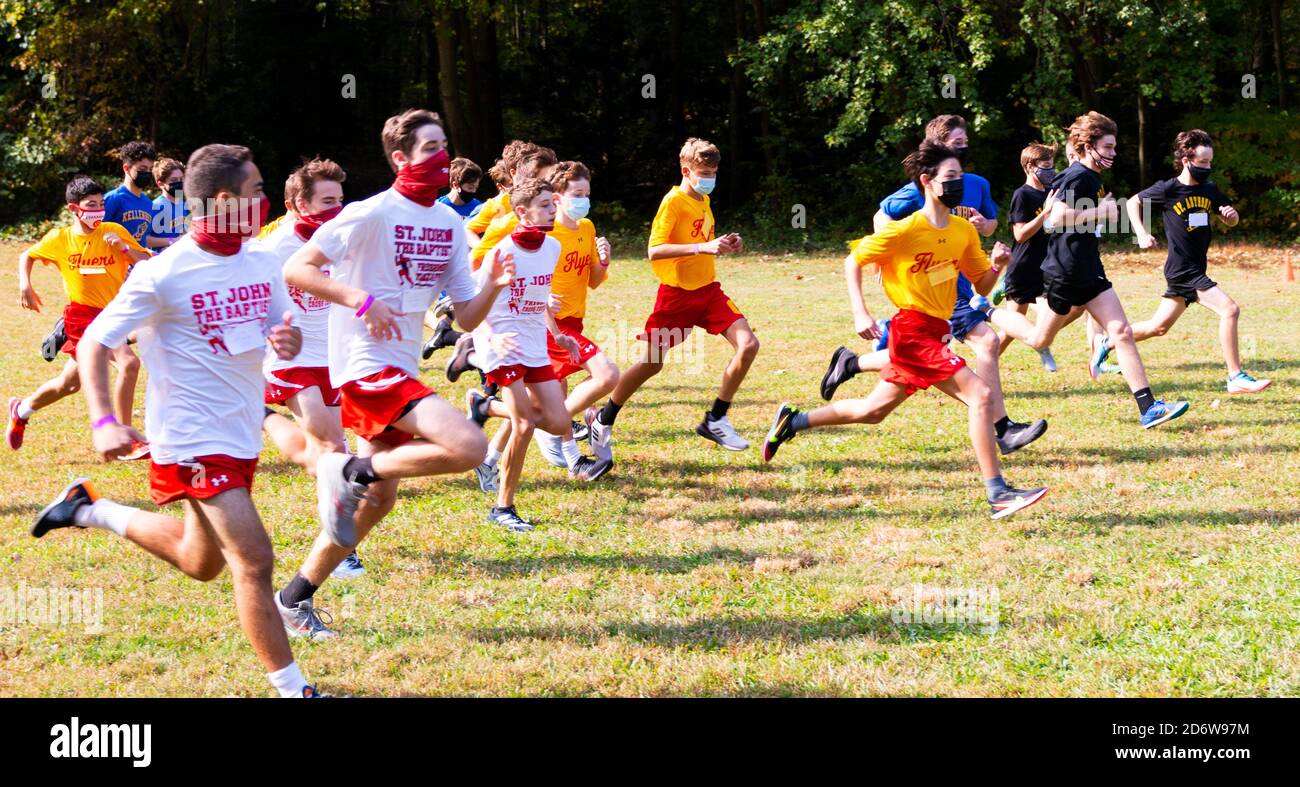Syosset, New York, USA - 10 ottobre 2020: L'inizio di una corsa di fondo dei ragazzi Freshmen durante la pandemia del coronavirus con corridori che indossano maschere. Foto Stock