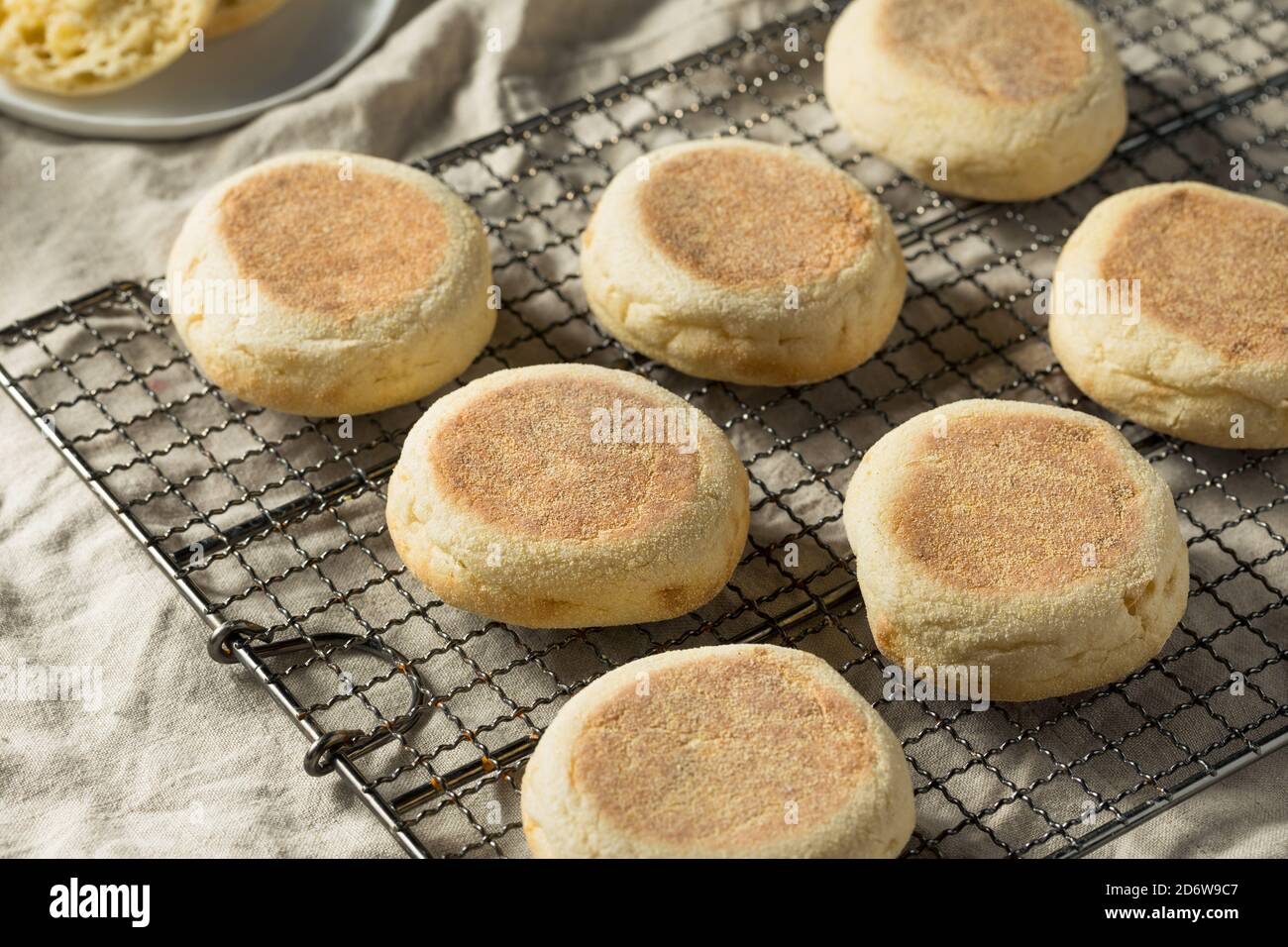 Muffin inglesi tostati fatti in casa con una linguetta di burro Foto Stock