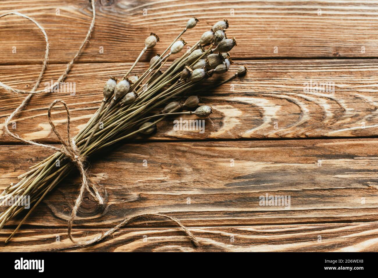vista dall'alto di papaveri secchi su sfondo di legno Foto Stock