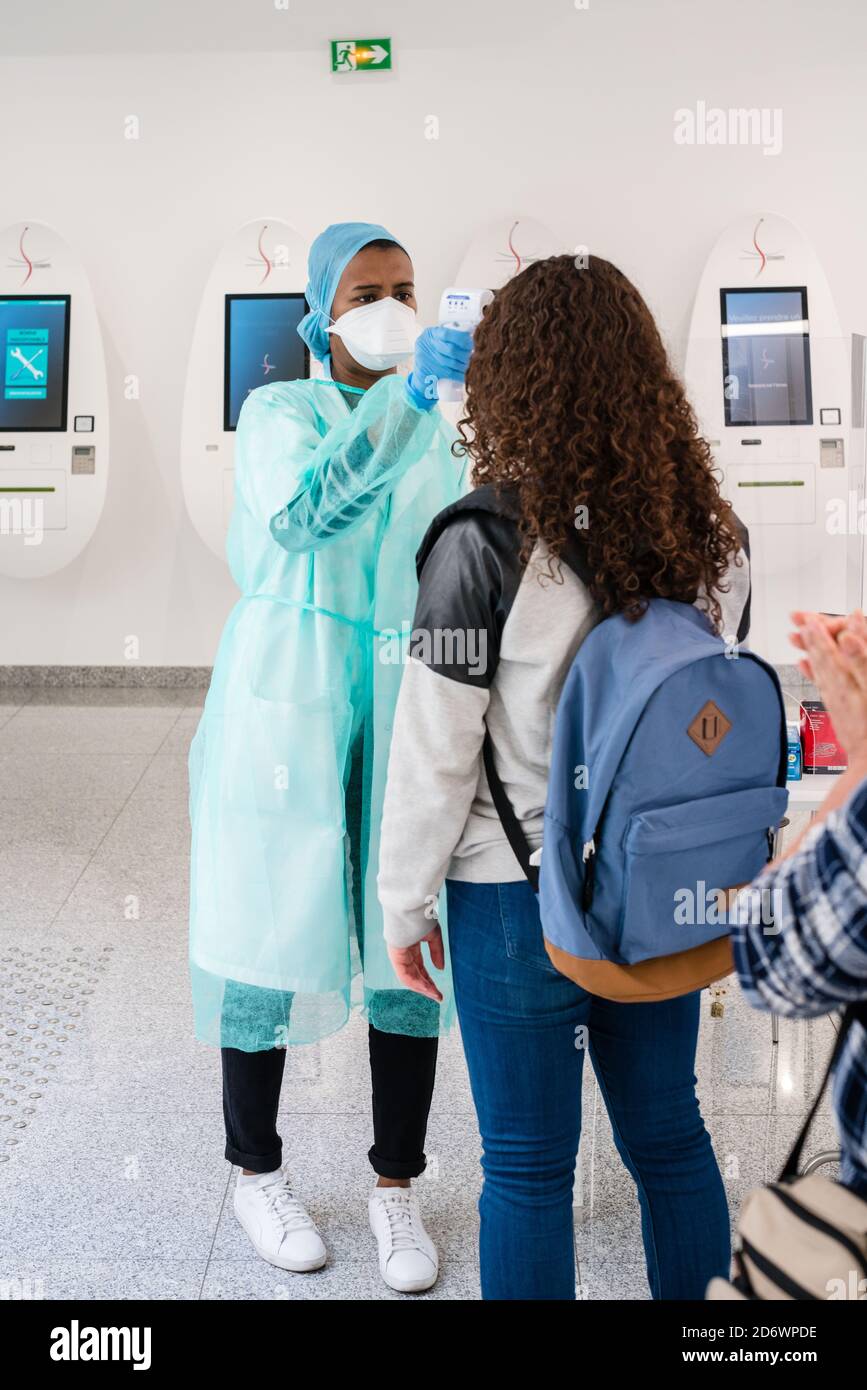 Misurazione della temperatura del paziente con un termometro per fronte alla reception del Cosem Atlas Medical Center, Parigi. Foto Stock