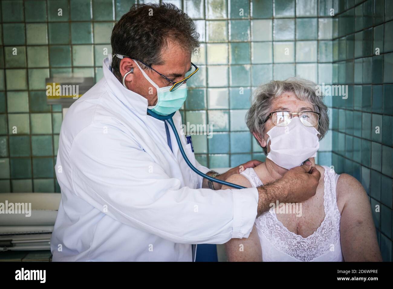 Donna in consultazione con un medico generico che indossa una maschera chirurgica, Francia, maggio 2020. Foto Stock