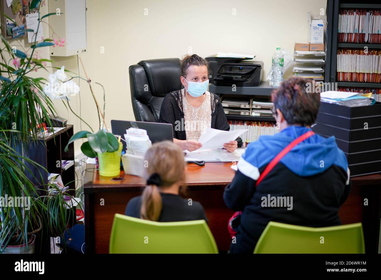 Ragazza in consultazione con un medico generico che indossa una maschera chirurgica, Francia, giugno 2020. Foto Stock