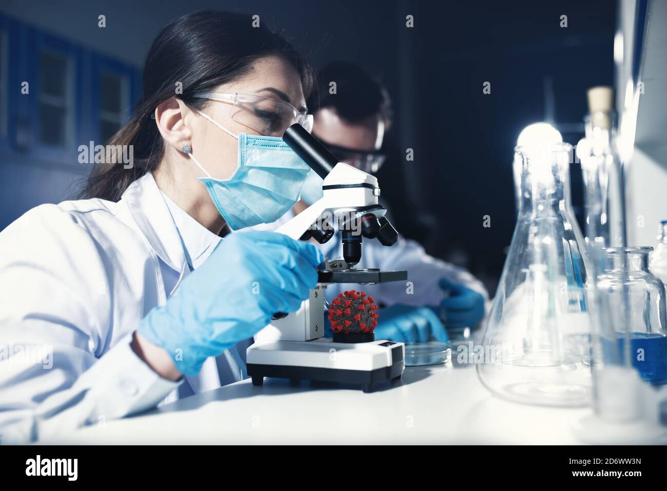 I medici in laboratorio analizzano i campioni al microscopio. Concetto di trattamento farmaceutico Foto Stock
