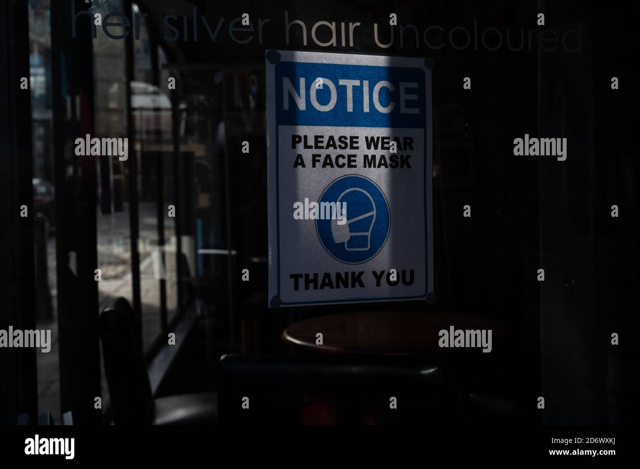 Si prega di indossare una maschera di avviso all'interno della finestra del caffè Foto Stock