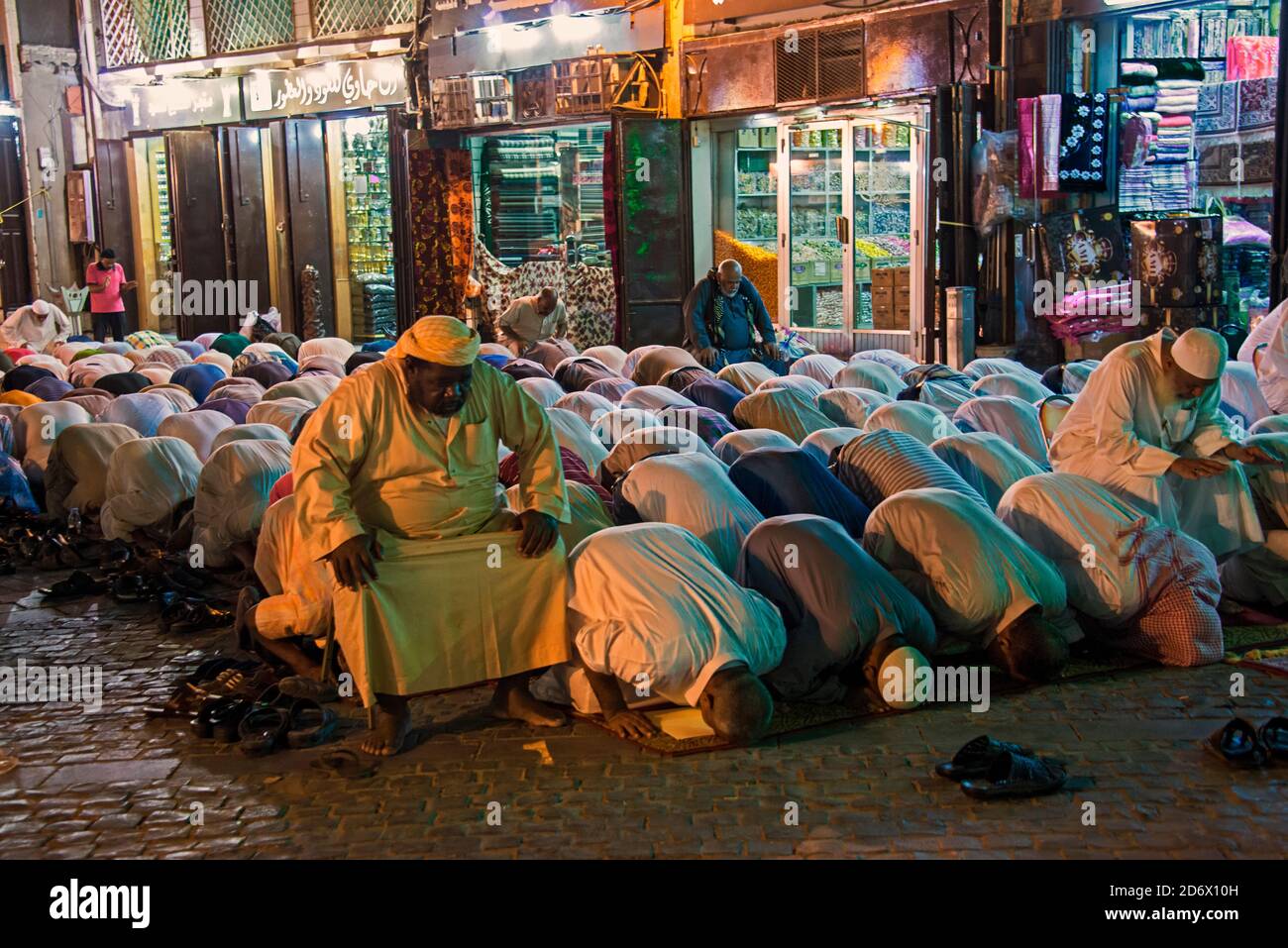 Gruppo di uomini che pregano per le strade di Jeddah, Arabia Saudita Foto Stock