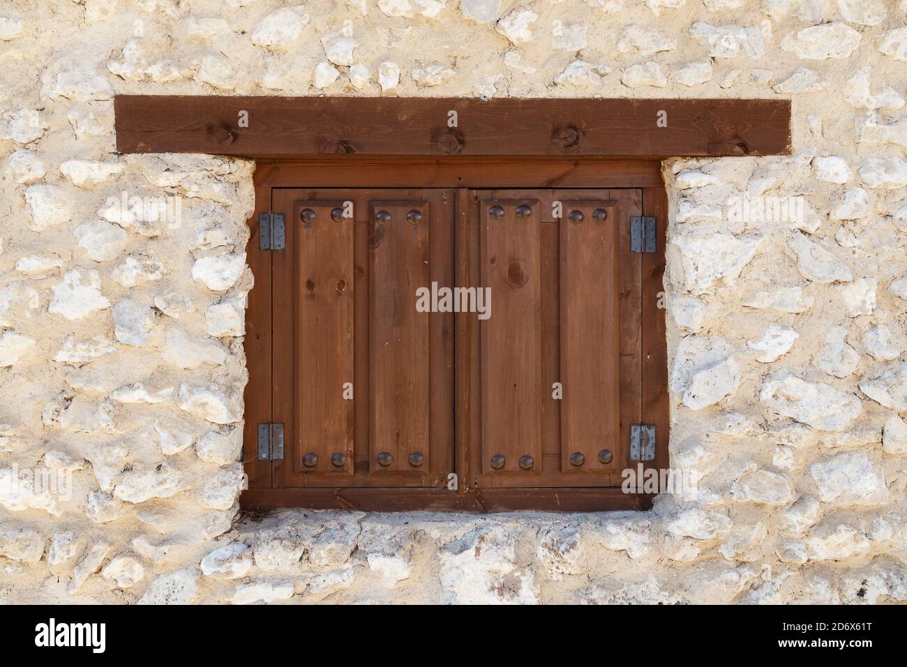 Primo piano di una piccola finestra in legno di un edificio in pietra sotto  la luce del sole Foto stock - Alamy
