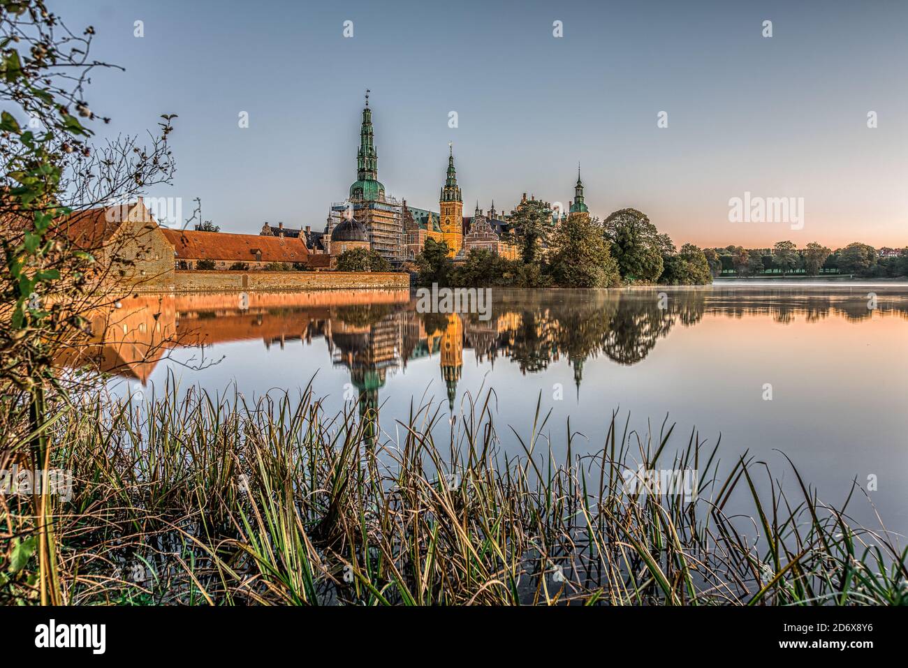 Il lago velato di Frederiksborg con canne e il castello sullo sfondo una tranquilla mattina di ottobre all'alba, Hillerod, Danimarca, 17,2020 ottobre Foto Stock