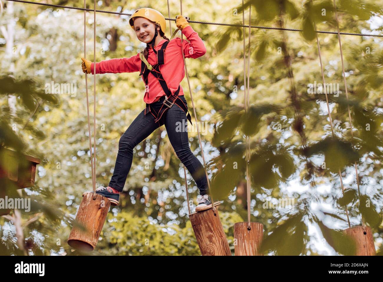 Le opere d'arte raffigurano i giochi all'eco resort che includono volpe volanti o rete di ragni. Bambino arrampicatore. Concetto di bambino. Casco e attrezzature di sicurezza. Bambino che gioca Foto Stock