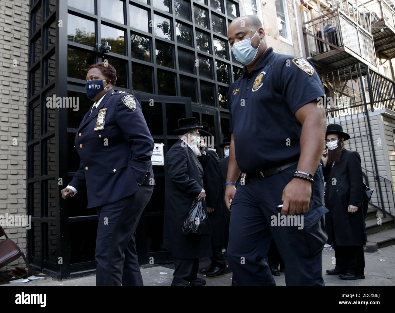 Brooklyn, Stati Uniti. 19 Ott 2020. Il capo Judith Harrison della NYPD cammina sul marciapiede mentre la gente si riunisce alla sinagoga Yetev Lev D'Fatmar nel quartiere Williamsburg di Brooklyn a New York City lunedì 19 ottobre 2020. La congregazione di Brooklyn ha pianificato un matrimonio Chassidico che i funzionari statali si aspettavano 10,000 persone a partecipare lunedì ha annunciato che non andrà più come previsto dopo che le autorità hanno ordinato una partecipazione limitata a causa del uptick nelle infezioni da coronavirus. Foto di John Angelillo/UPI Credit: UPI/Alamy Live News Foto Stock