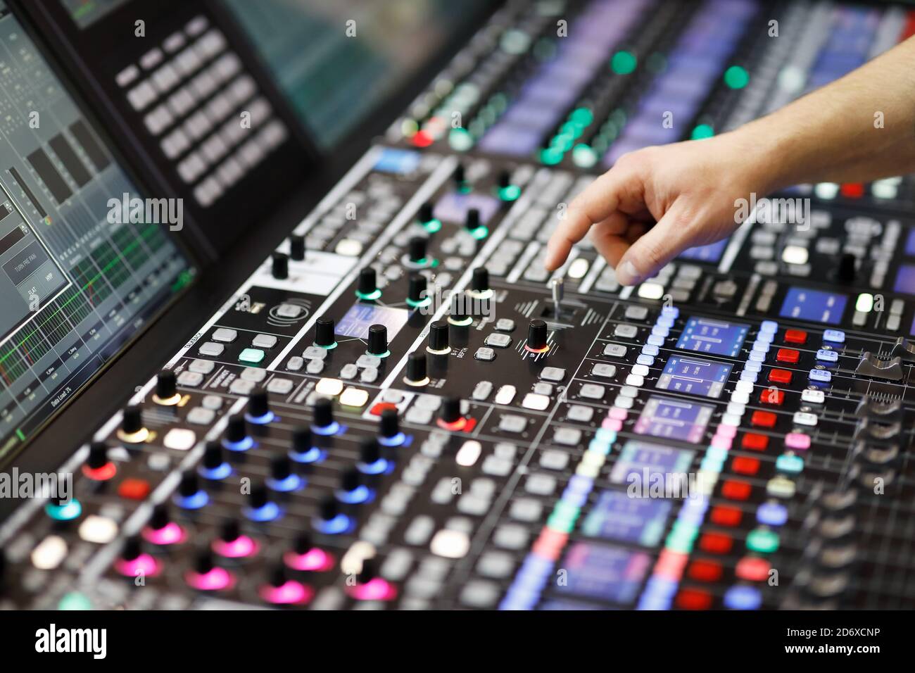 L'operatore regola i comandi del pannello del mixer audio nello studio di registrazione. Messa a fuoco selettiva. Foto Stock