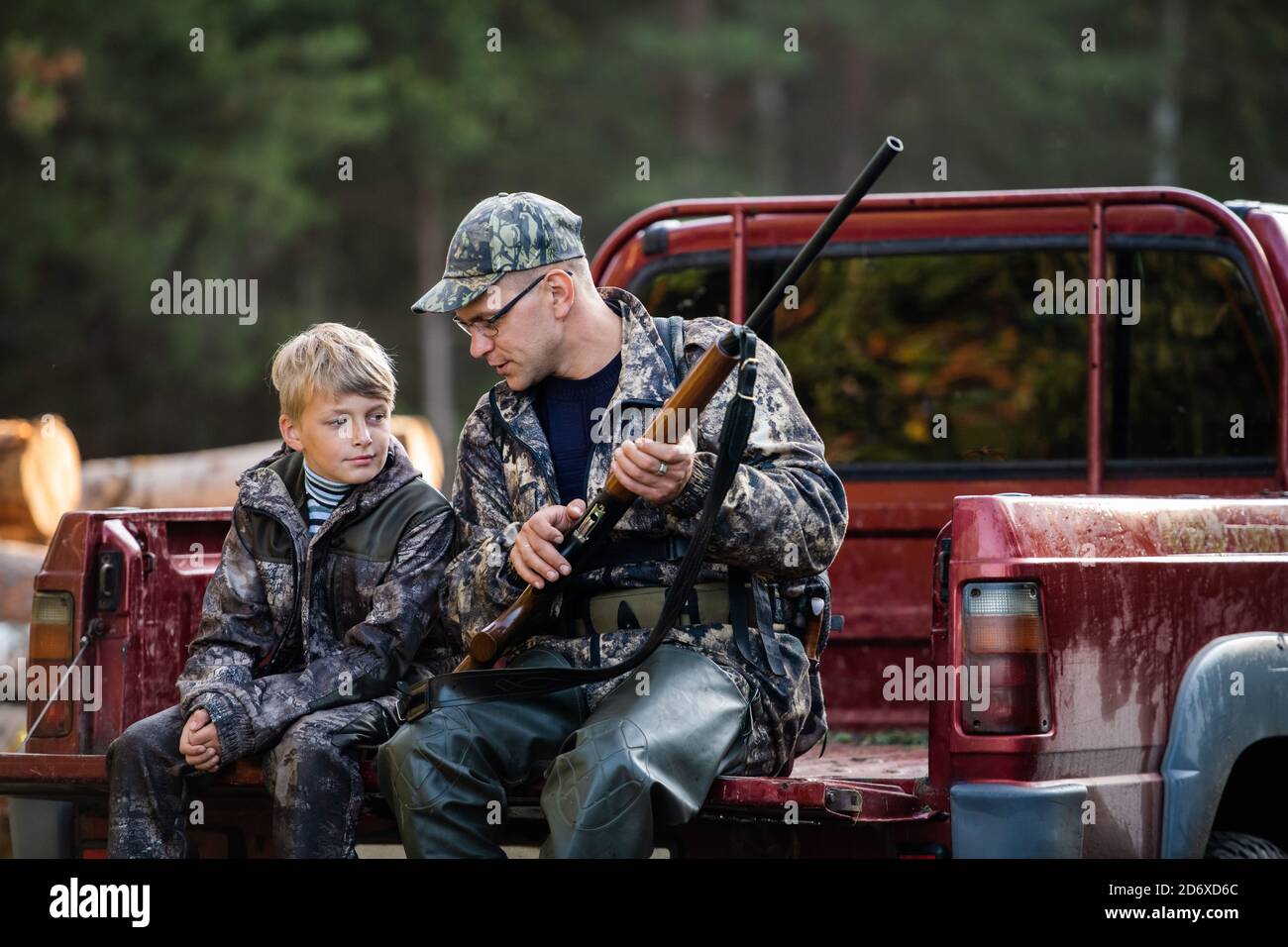 Padre in un cappello e suo figlio seduto in una macchina dopo la caccia. Foto Stock