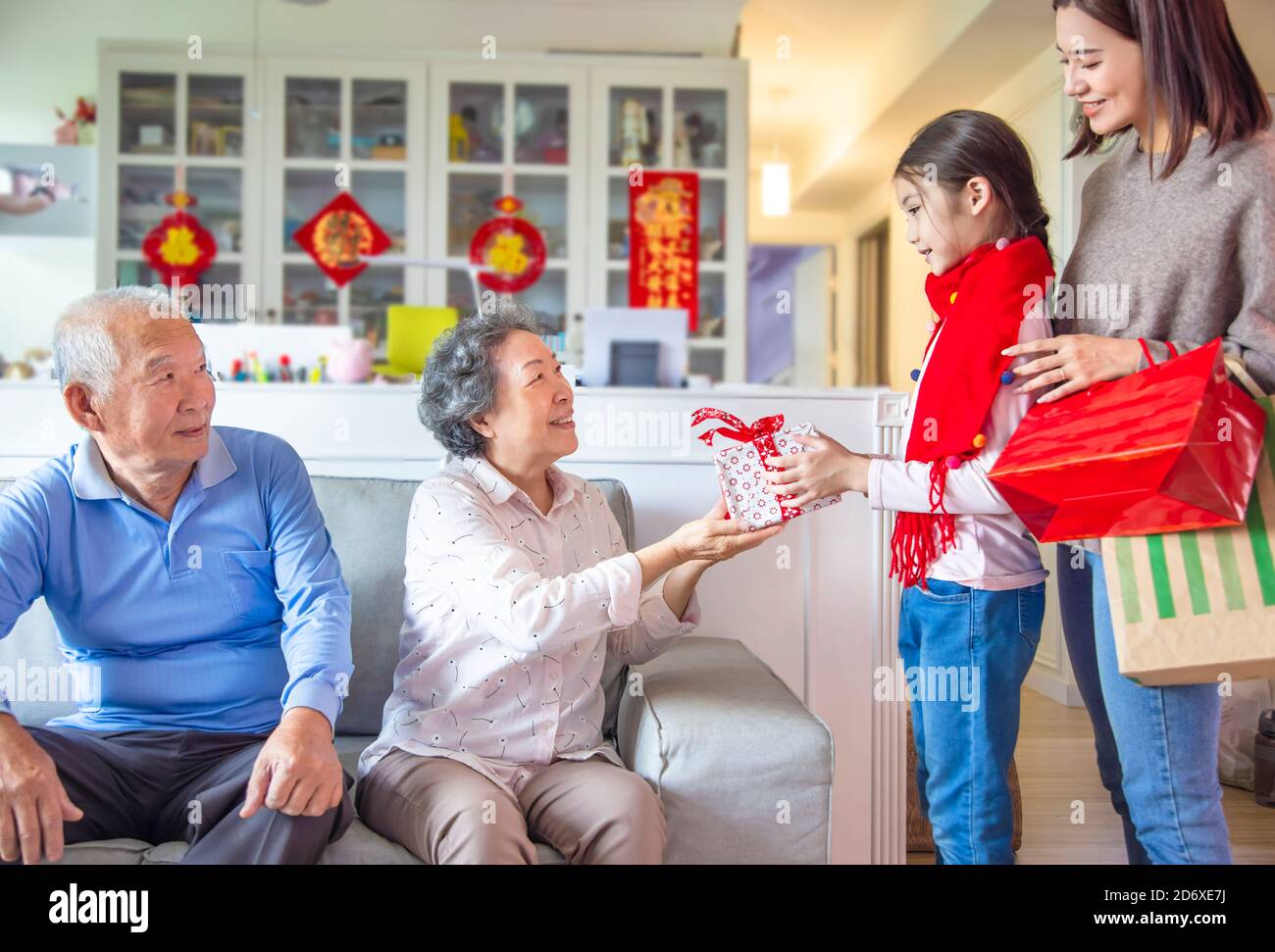 bambina che dà dono al nonno per il nuovo anno cinese Foto Stock